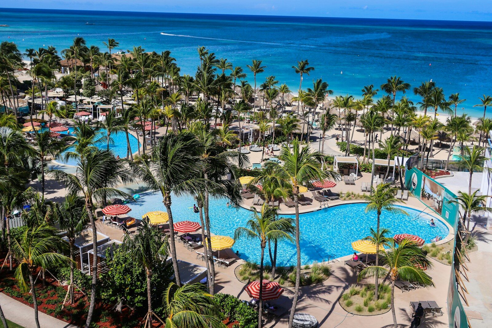 Tropical resort with pools and palm trees by the ocean